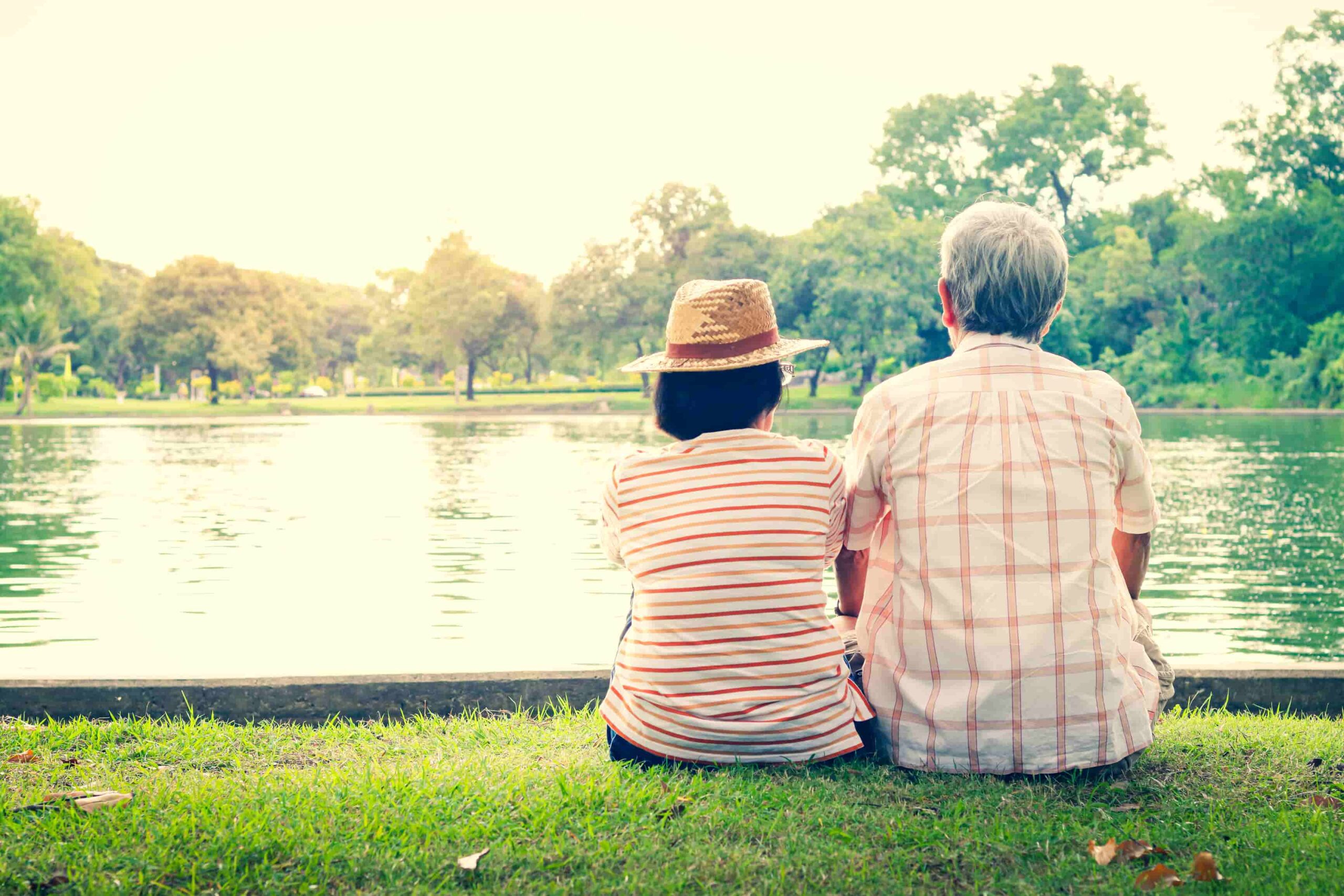 old couple sitting at a pond
